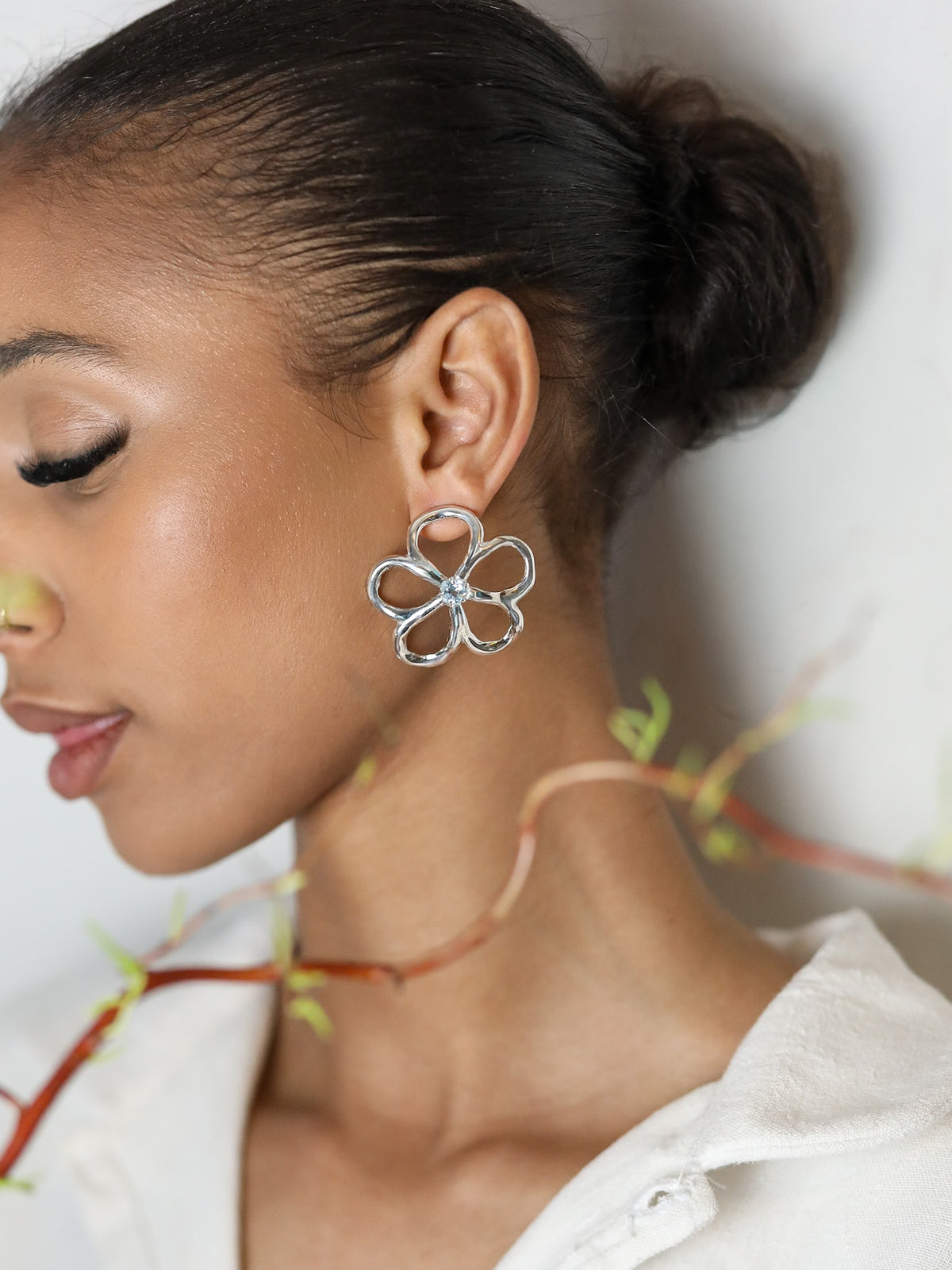 Boucles d'oreilles Aura en argent 925, fleur serties de pierres d'intention porté de profil — Collection Éclosion