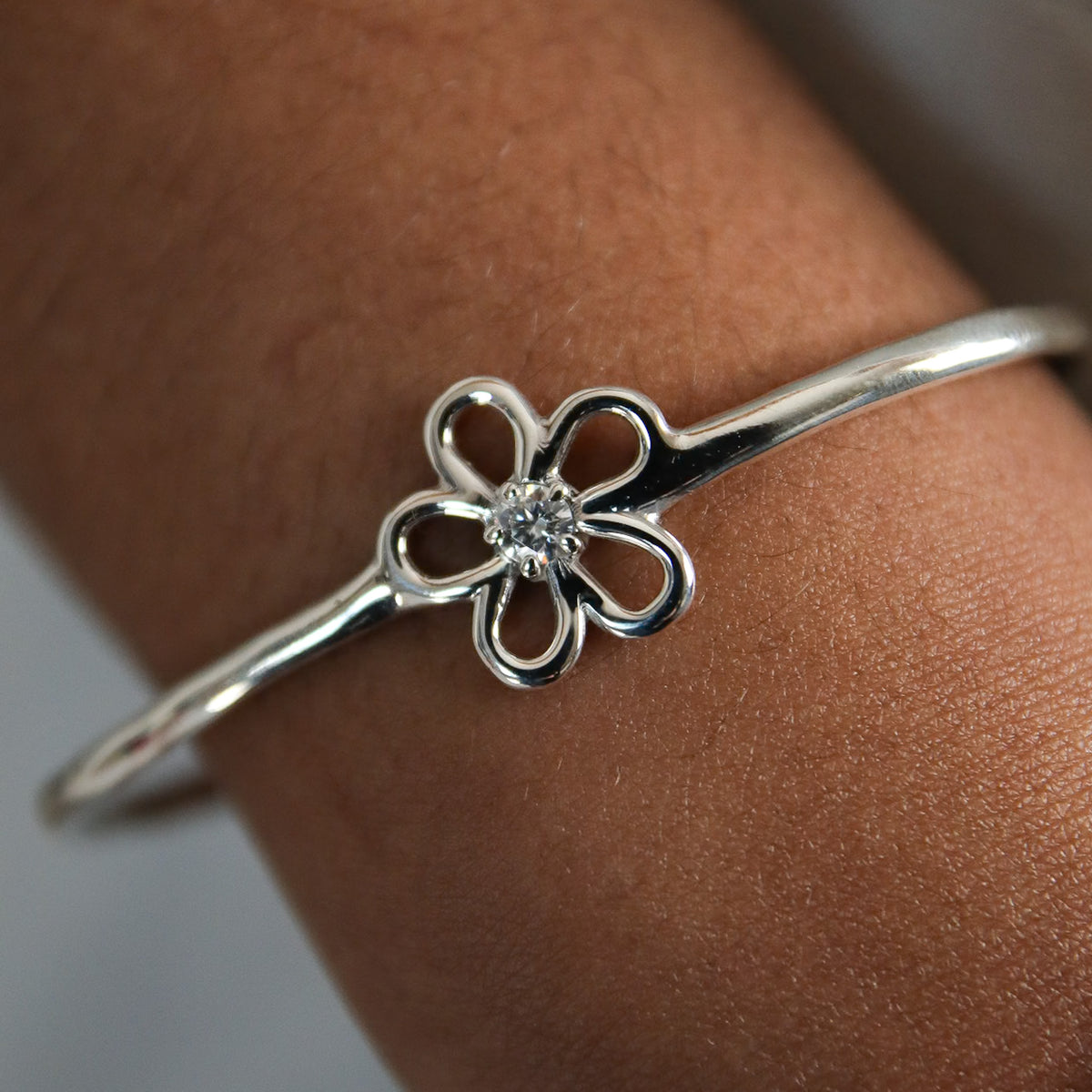 Jonc Sérénité en argent 925, fleur serti de pierres d'intention gros plan porté — Collection Éclosion