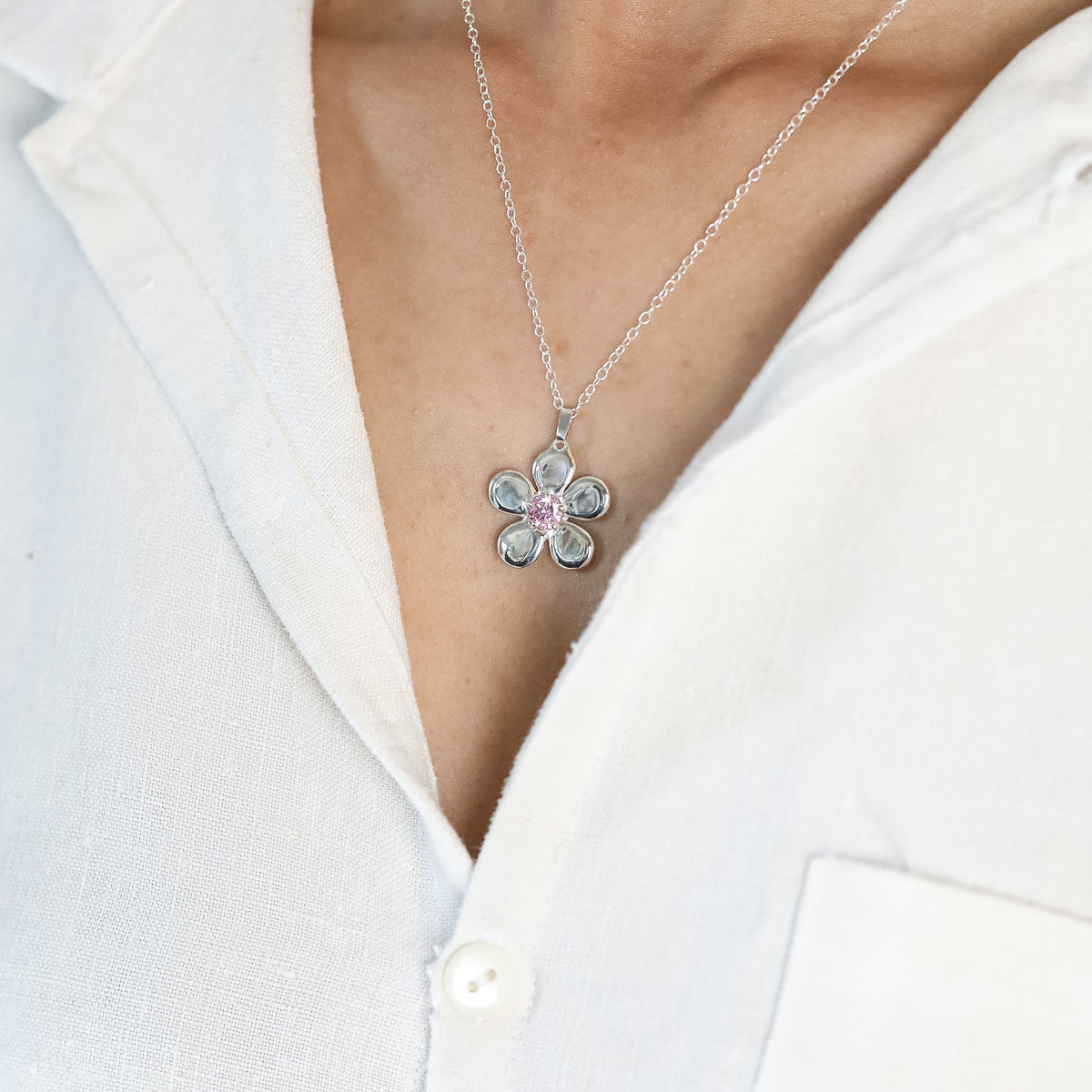 Pendentif Ouverture en argent 925, fleur serti de pierres d'intention porté chemise blanche — Collection Éclosion